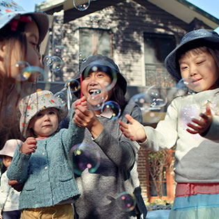 Children playing with bubbles outdoors.
