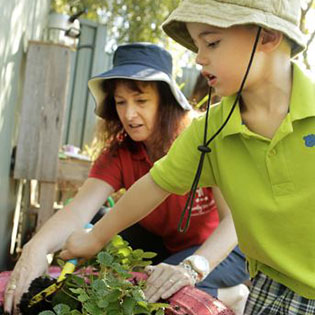 Child and adult gardening together outdoors.